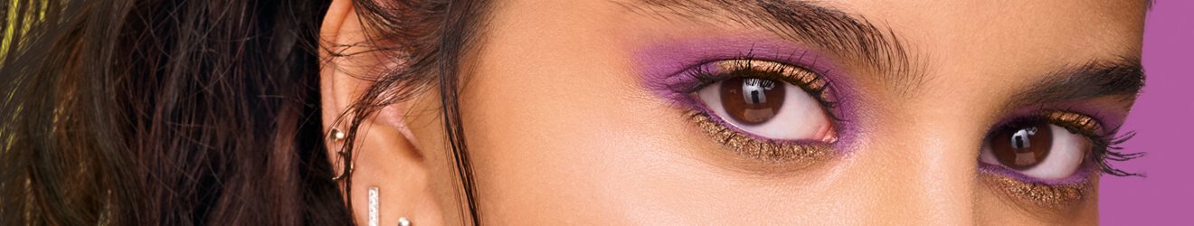 Maybelline Eyeshadow products illustrative banner image - Close up of blond Asian woman with headphones, wearing colorfull Eyeshadow