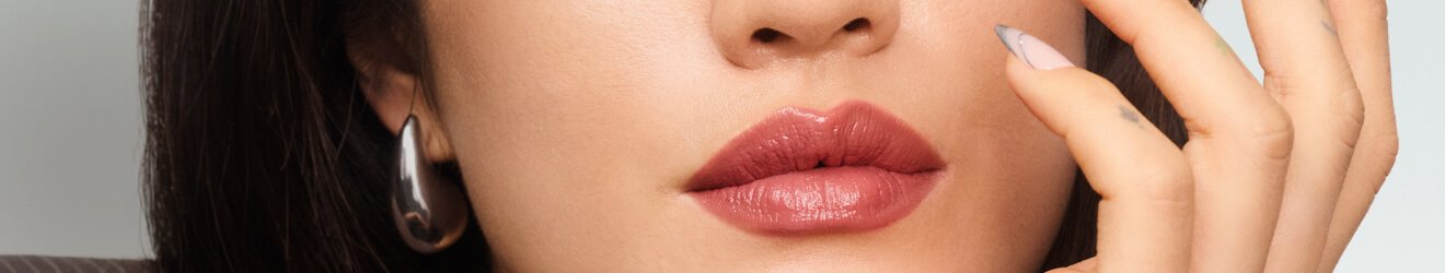Maybelline Lipstick products illustrative banner image - Close up of woman wearing bright lipstick